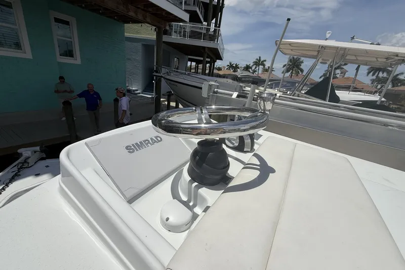 Slide: The Image of 2023 Yellowfin 26 Hybrid boat with Simrad electronics, docked near waterfront homes. - 36