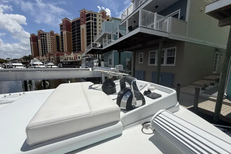 Slide: The Image of 2023 Yellowfin 26 Hybrid boat docked near waterfront buildings under a blue sky. - 37