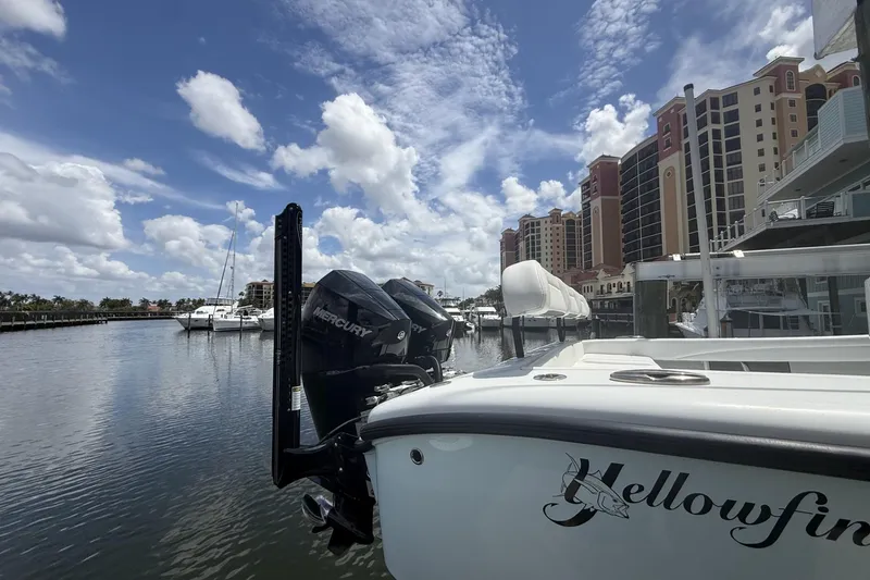 Slide: The Image of 2023 Yellowfin 26 Hybrid boat docked in marina with waterfront buildings. - 6