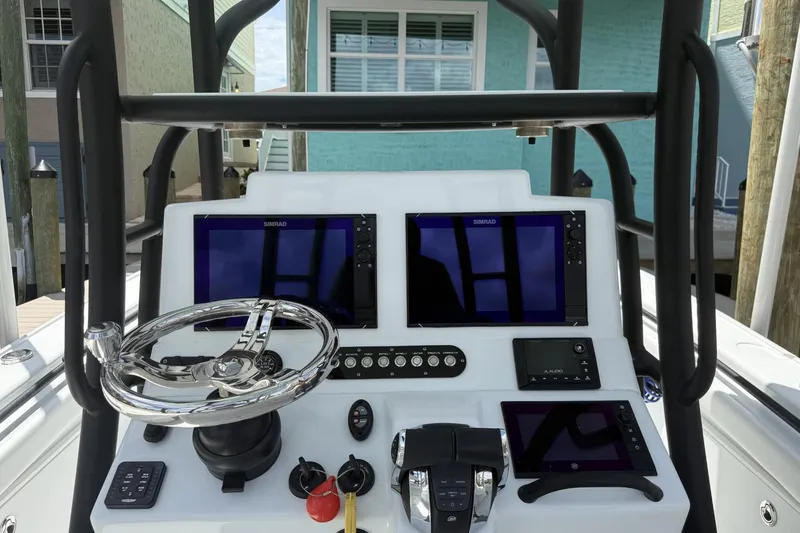 Slide: The Image of 2023 Yellowfin 26 Hybrid boat dashboard with dual Simrad displays and steering wheel. - 8