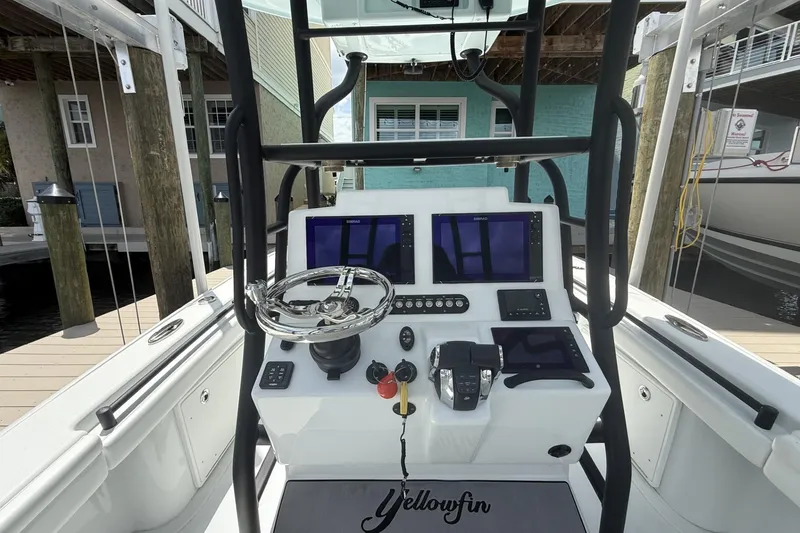 Slide: The Image of 2023 Yellowfin 26 Hybrid boat dashboard with steering wheel and navigation screens. - 9