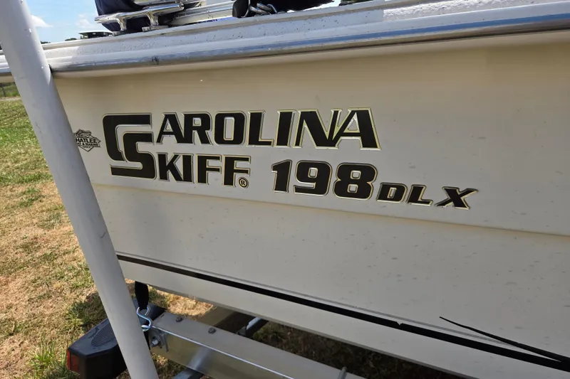 Slide: The Image of 2017 Carolina Skiff 198 DLX boat side view with logo and model details. - 10