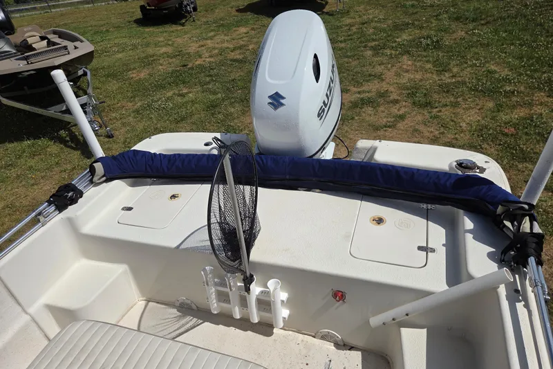 Slide: The Image of 2017 Carolina Skiff 198 DLX boat with Suzuki outboard motor, fishing net, and rod holders. - 19