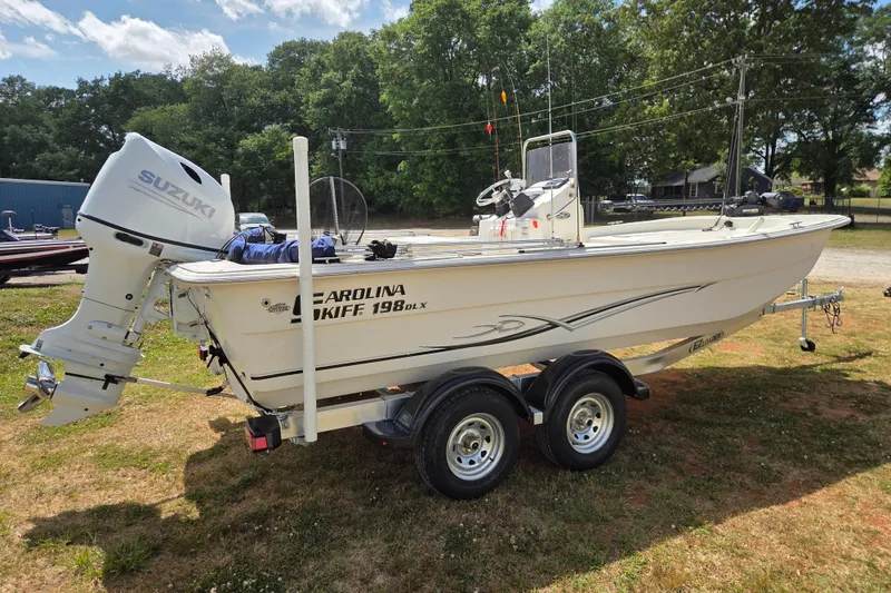 Slide: The Image of 2017 Carolina Skiff 198 DLX boat with Suzuki outboard motor on trailer. - 4