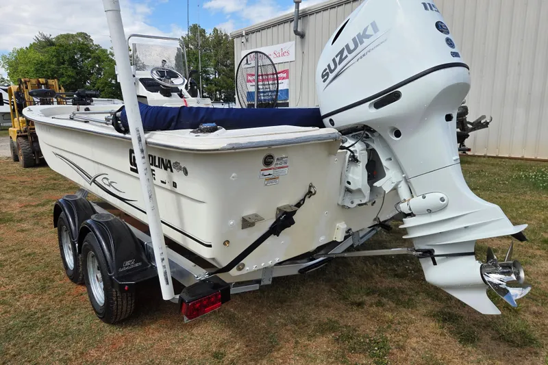 Slide: The Image of 2017 Carolina Skiff 198 DLX boat with Suzuki outboard motor on trailer. - 7
