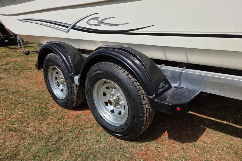 Slide: The Image of Trailer with dual wheels for 2017 Carolina Skiff 198 DLX boat on grass. - 9