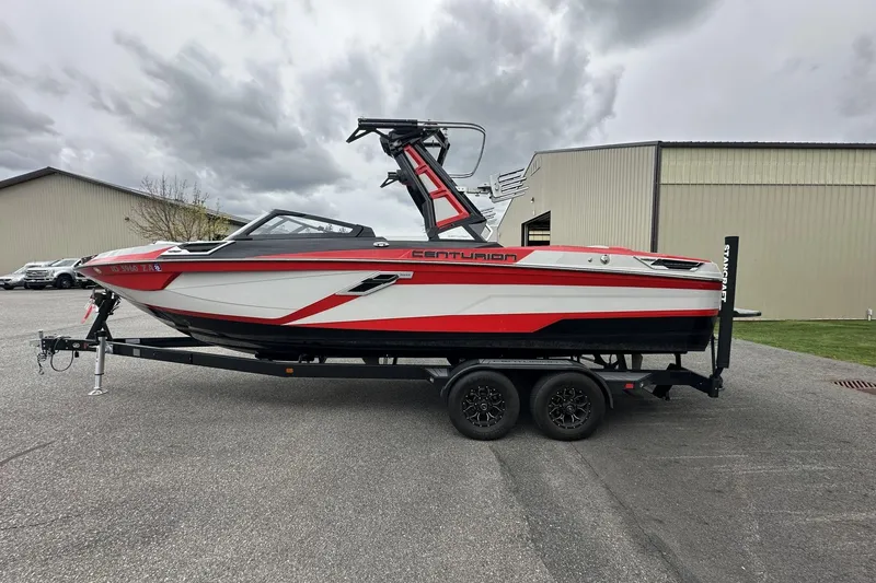 The Image of 2021 Centurion Ri245 boat on trailer, red and white design, parked outdoors. - 1