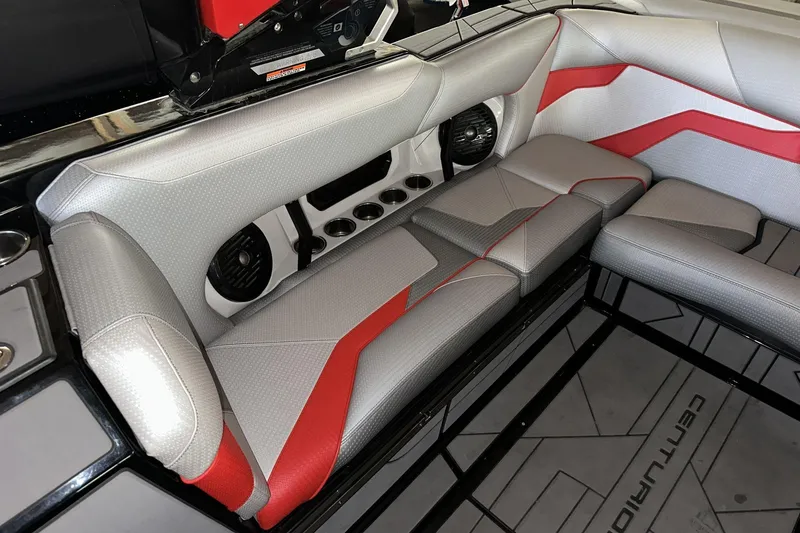 Slide: The Image of 2021 Centurion Ri245 boat interior with gray and red seating, cup holders, and speakers. - 12