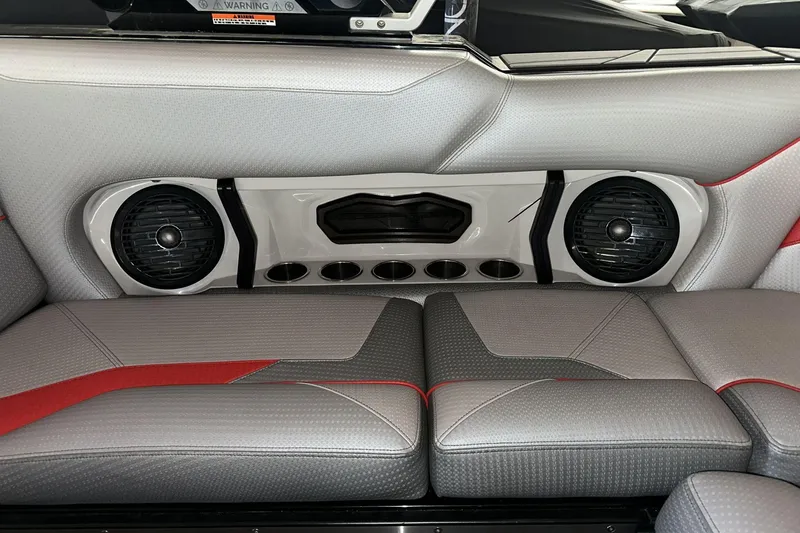 Slide: The Image of 2021 Centurion Ri245 boat interior with speakers and cup holders, featuring gray and red upholstery. - 15