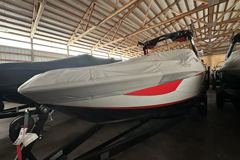 Slide: The Image of 2021 Centurion Ri245 boat covered in storage, featuring red and white design. - 5