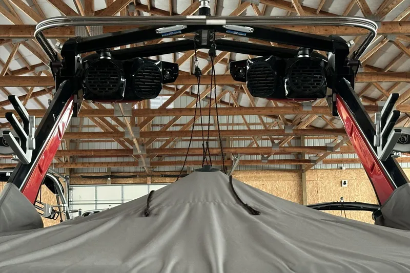 Slide: The Image of 2021 Centurion Ri245 boat with speakers and cover in a wooden garage. - 7