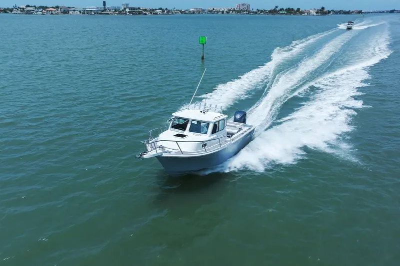 Slide: The Image of 2024 Parker 2320 Sport Cabin boat cruising on water. - 14