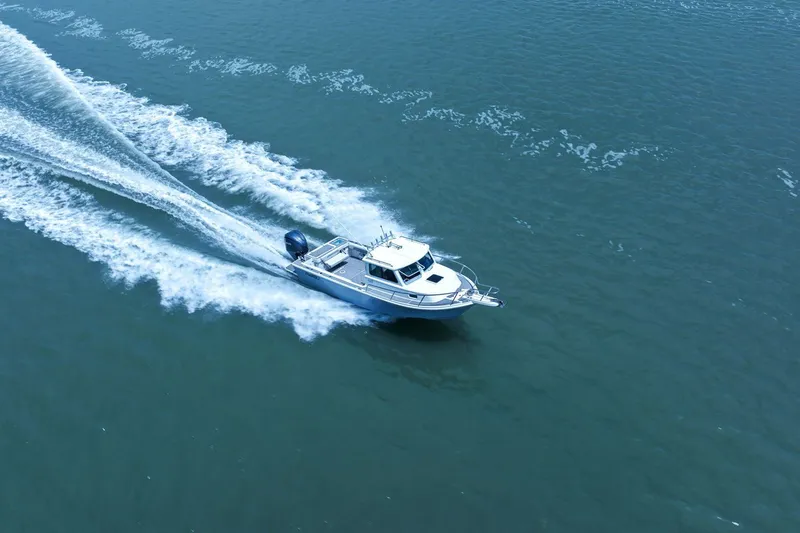 Slide: The Image of Parker 2320 Sport Cabin 2024 cruising swiftly on open water. - 19