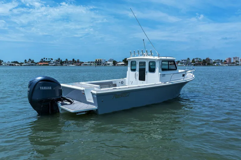 Slide: The Image of 2024 Parker 2320 Sport Cabin boat on calm water. - 2