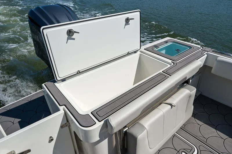 Slide: The Image of Parker 2320 Sport Cabin 2024 with open storage compartment on water. - 23