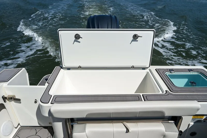 Slide: The Image of Parker 2320 Sport Cabin 2024 with open storage compartment on water. - 24