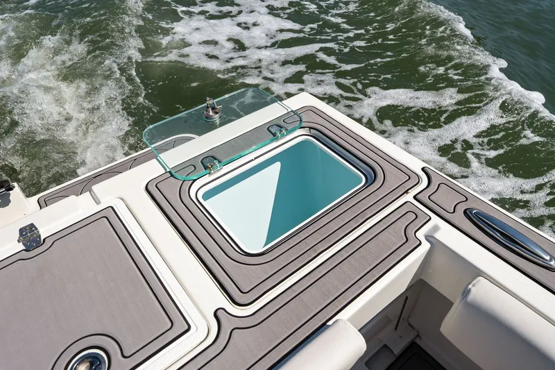 Slide: The Image of Parker 2320 Sport Cabin 2024 with open storage compartment on water. - 25
