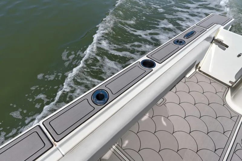 Slide: The Image of Parker 2320 Sport Cabin 2024, boat deck with cup holders on water. - 28