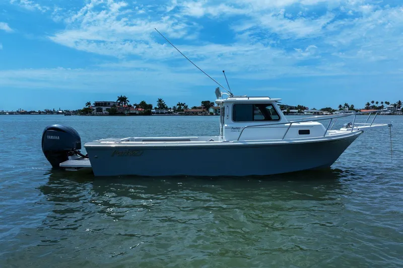 Slide: The Image of 2024 Parker 2320 Sport Cabin boat on calm water. - 3