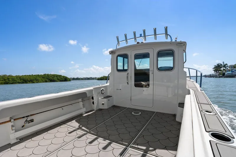 Slide: The Image of Parker 2320 Sport Cabin 2024 on calm waters with blue sky. - 32