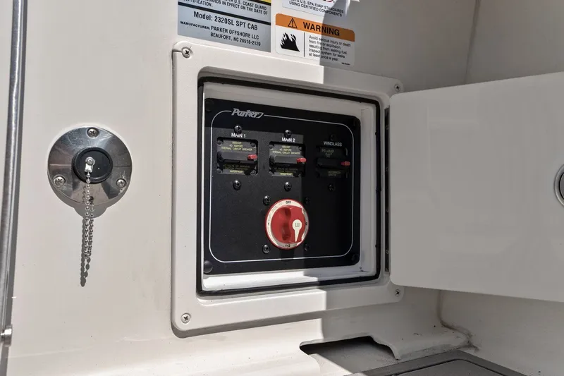 Slide: The Image of Parker 2320 Sport Cabin 2024 control panel with circuit breakers and switches. - 35