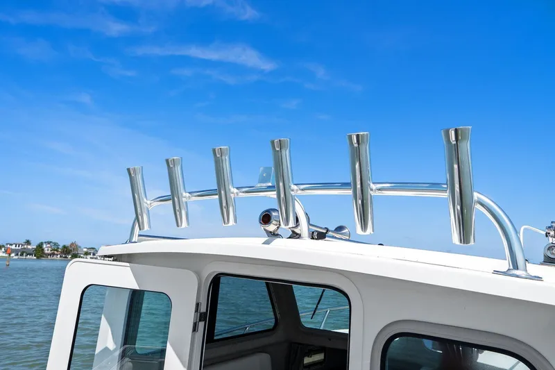 Slide: The Image of Parker 2320 Sport Cabin 2024 with rod holders, blue sky. - 39