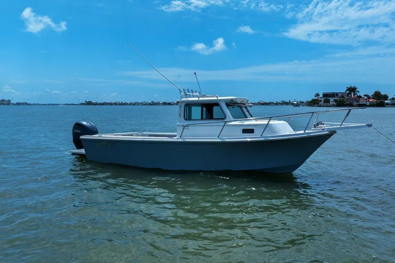 Slide: The Image of Parker 2320 Sport Cabin 2024 on calm water under clear sky. - 4