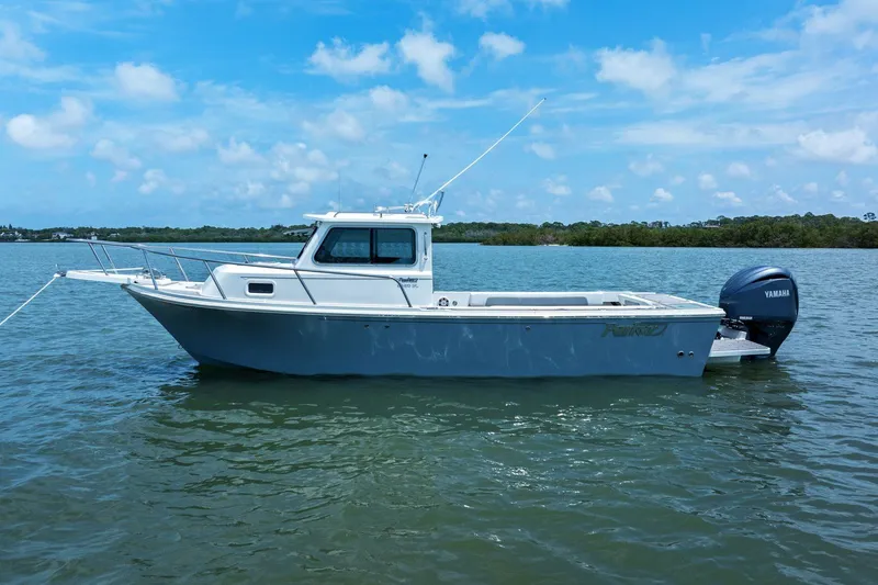Slide: The Image of 2024 Parker 2320 Sport Cabin boat on calm water. - 6