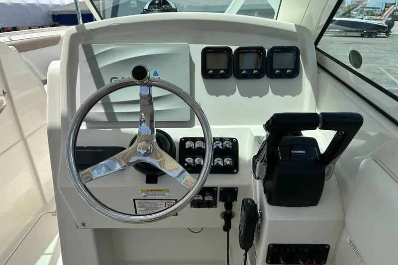 Slide: The Image of Control panel of a 2015 Sailfish 275 DC boat with steering wheel and Yamaha throttle. - 25