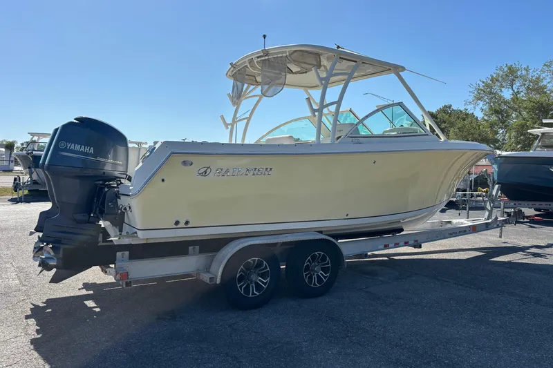 Slide: The Image of 2015 Sailfish 275 DC boat on trailer with Yamaha engine, parked outdoors. - 2