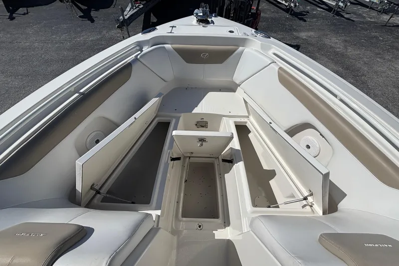 Slide: The Image of 2015 Sailfish 275 DC boat interior with open storage compartments and cushioned seating. - 6
