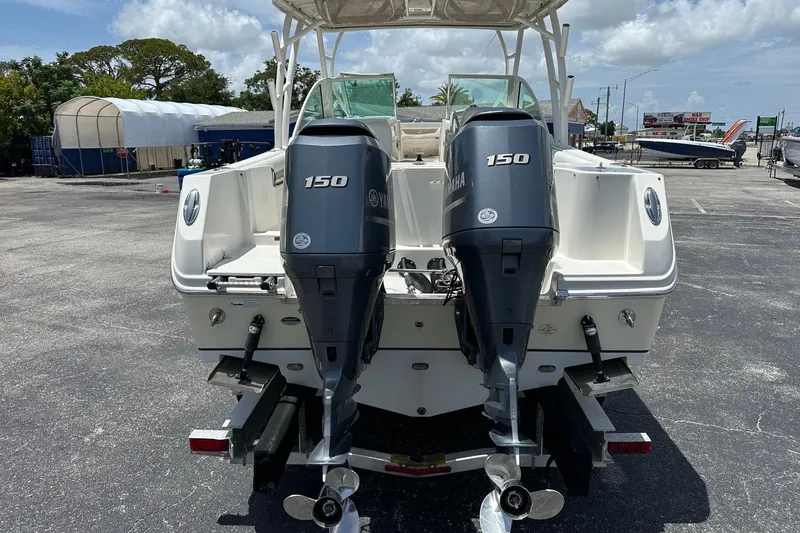 Slide: The Image of 2015 Sailfish 275 DC boat with dual Yamaha 150 engines in a marina setting. - 5