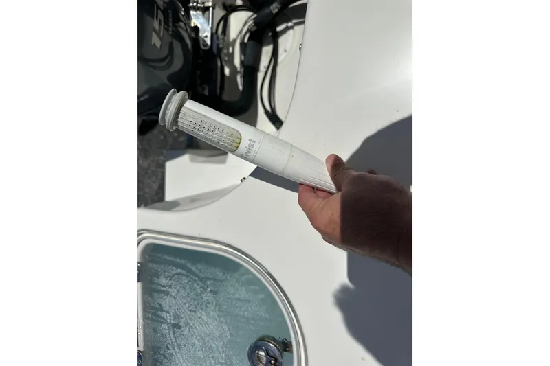 Slide: The Image of Hand holding a filter on a 2015 Sailfish 275 DC boat deck. - 39