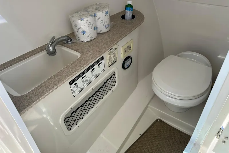 Slide: The Image of 2015 Sailfish 275 DC boat bathroom with sink, toilet, and storage. - 23