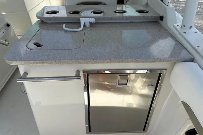 Slide: The Image of 2015 Sailfish 275 DC boat kitchenette with sink, countertop, and built-in storage. - 31