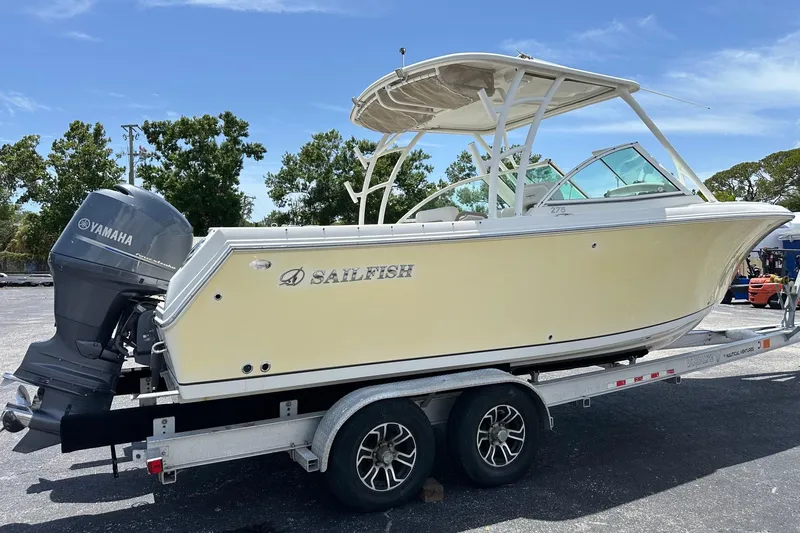 Slide: The Image of 2015 Sailfish 275 DC boat on trailer with Yamaha engine, parked outdoors. - 4