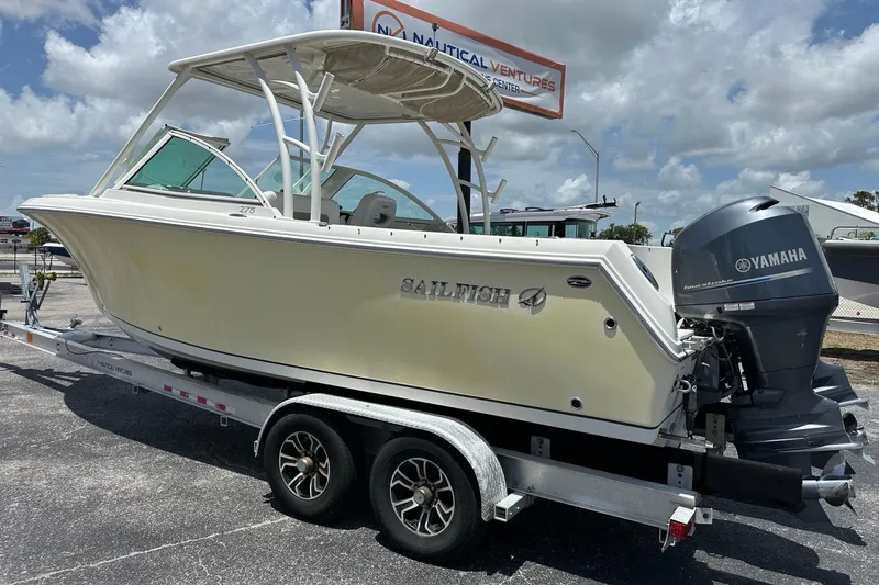 Slide: The Image of 2015 Sailfish 275 DC boat on trailer with Yamaha outboard motor, parked outdoors. - 6