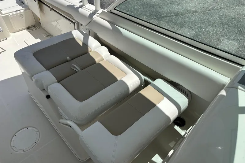 Slide: The Image of 2015 Sailfish 275 DC boat interior with beige and white cushioned seating. - 21