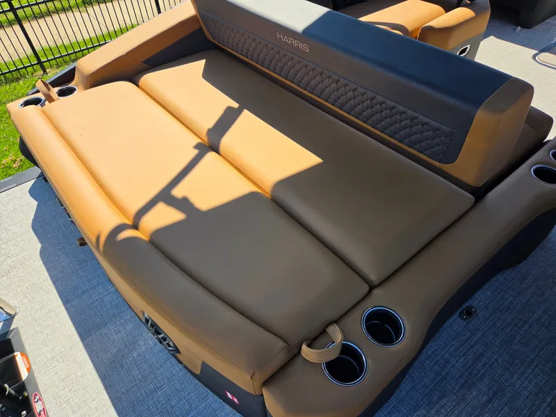 Slide: The Image of The image shows the rear seating of a 2027 Harris Sunliner 230 with brown upholstery and cup holders. - 27