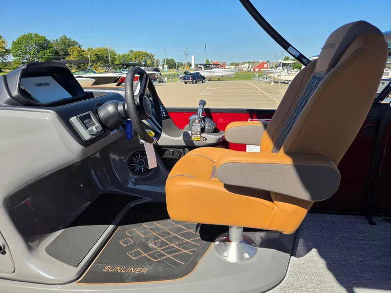 Slide: The Image of The image shows the helm of a 2027 Harris Sunliner 230 with a comfortable captain's chair. - 19