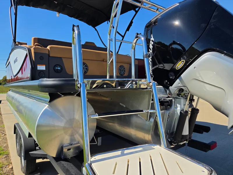 Slide: The Image of The image shows the rear of a Harris Sunliner 230 pontoon boat with motor and swim ladder. - 6