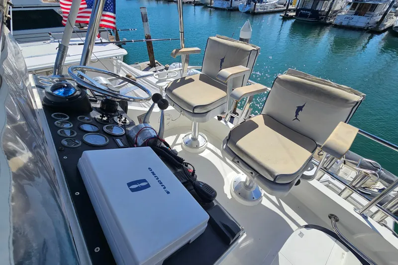 Slide: The Image of Cockpit of 1990 Mediterranean 38 Convertible yacht with steering wheel and cushioned chairs. - 10