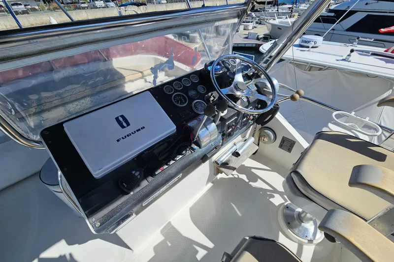 Slide: The Image of Cockpit of 1990 Mediterranean 38 Convertible yacht with steering wheel and navigation equipment. - 11