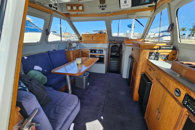 Slide: The Image of Interior of 1990 Mediterranean 38 Convertible yacht with wooden cabinetry and blue seating. - 15