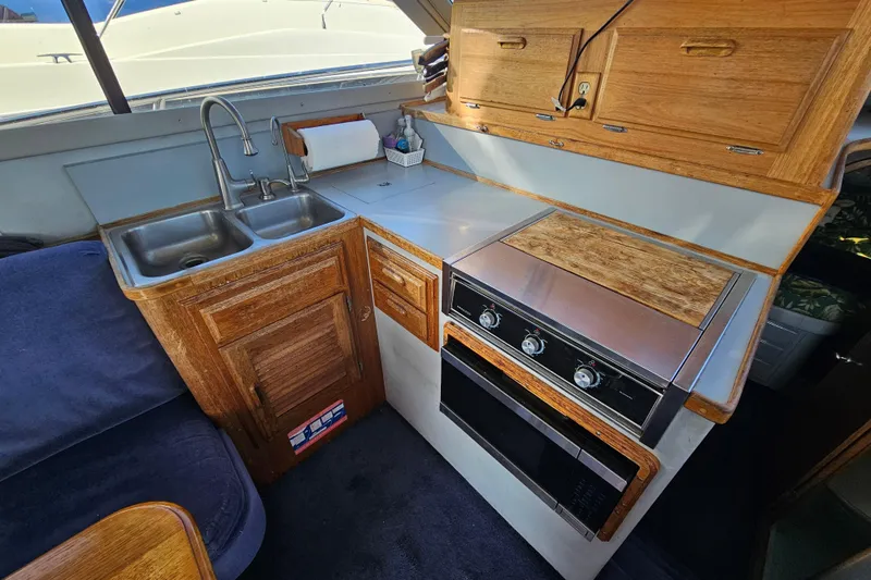 Slide: The Image of Compact kitchen in a 1990 Mediterranean 38 Convertible yacht with wooden cabinetry and stainless steel sink. - 17