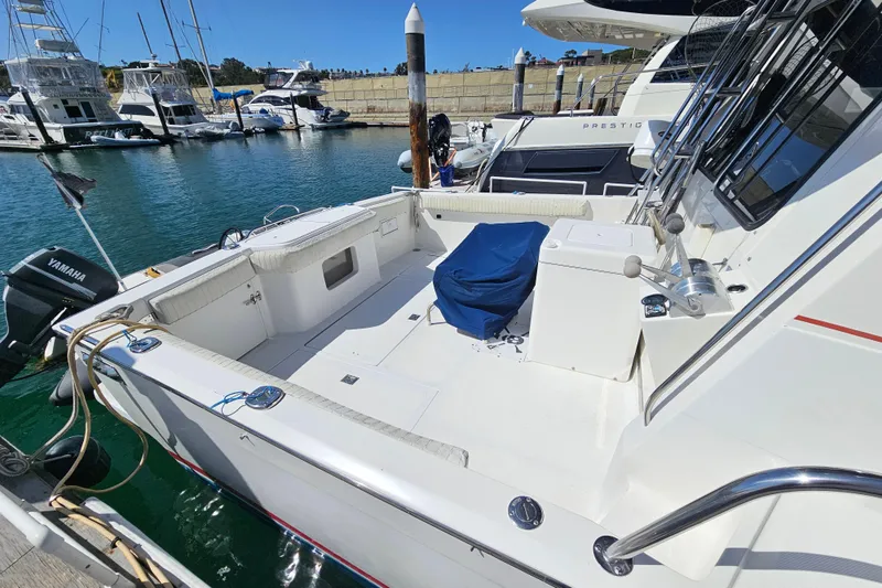 Slide: The Image of 1990 Mediterranean 38 Convertible yacht docked at marina, featuring spacious deck and Yamaha engine. - 2
