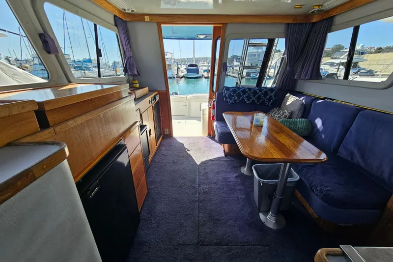 Slide: The Image of Interior of a 1990 Mediterranean 38 Convertible yacht with cozy seating and marina view. - 20