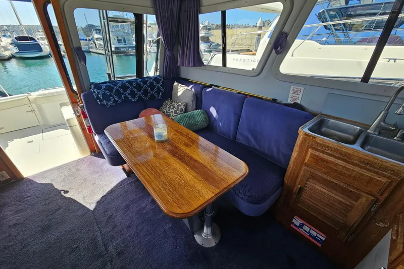 Slide: The Image of Interior of 1990 Mediterranean 38 Convertible yacht with cozy seating and wooden table. - 21