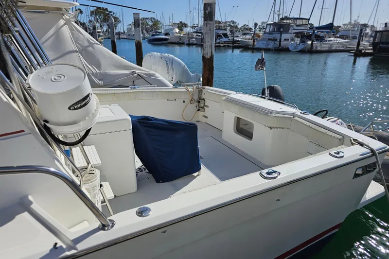 Slide: The Image of 1990 Mediterranean 38 Convertible yacht docked at marina, featuring spacious deck and equipment. - 3