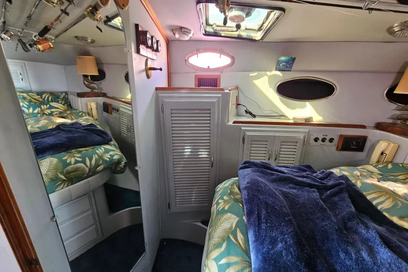 Slide: The Image of Cozy cabin interior of a 1990 Mediterranean 38 Convertible yacht with floral bedding. - 30